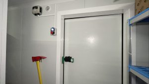 interior de una cámara refrigerdada con hacha y boton de persona cerrad